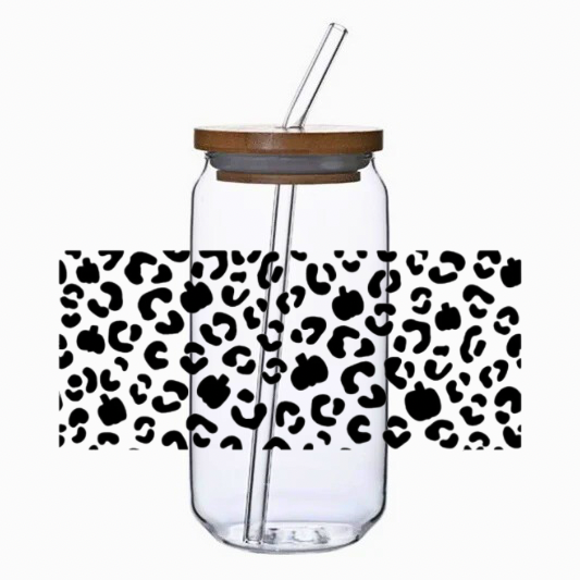 Clear glass tumbler with leopard and pumpkins print pattern, bamboo lid, and straw on a white background