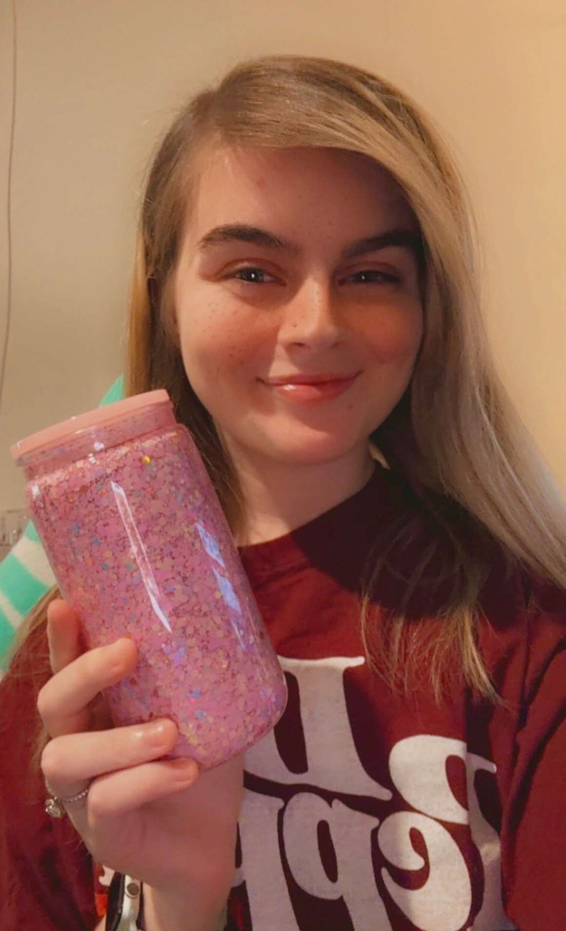 Person holding a pink glittery tumbler with a neutral background