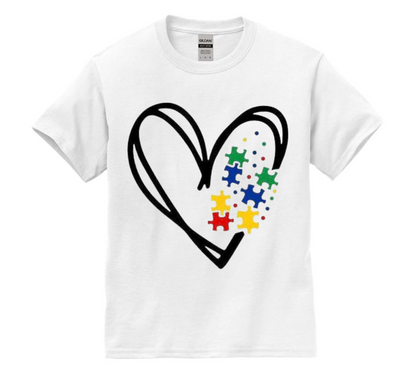 White t-shirt with a heart design featuring colorful puzzle pieces on a white background