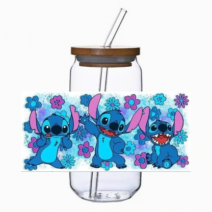 Glass tumbler with a straw and blue alien cartoon character on a white background