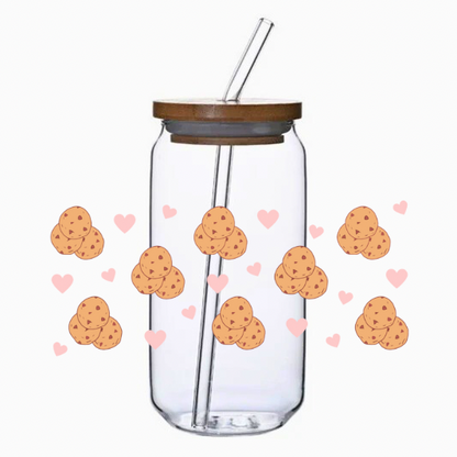Clear glass tumbler with bamboo lid and straw, decorated with cookies and hearts on a white background