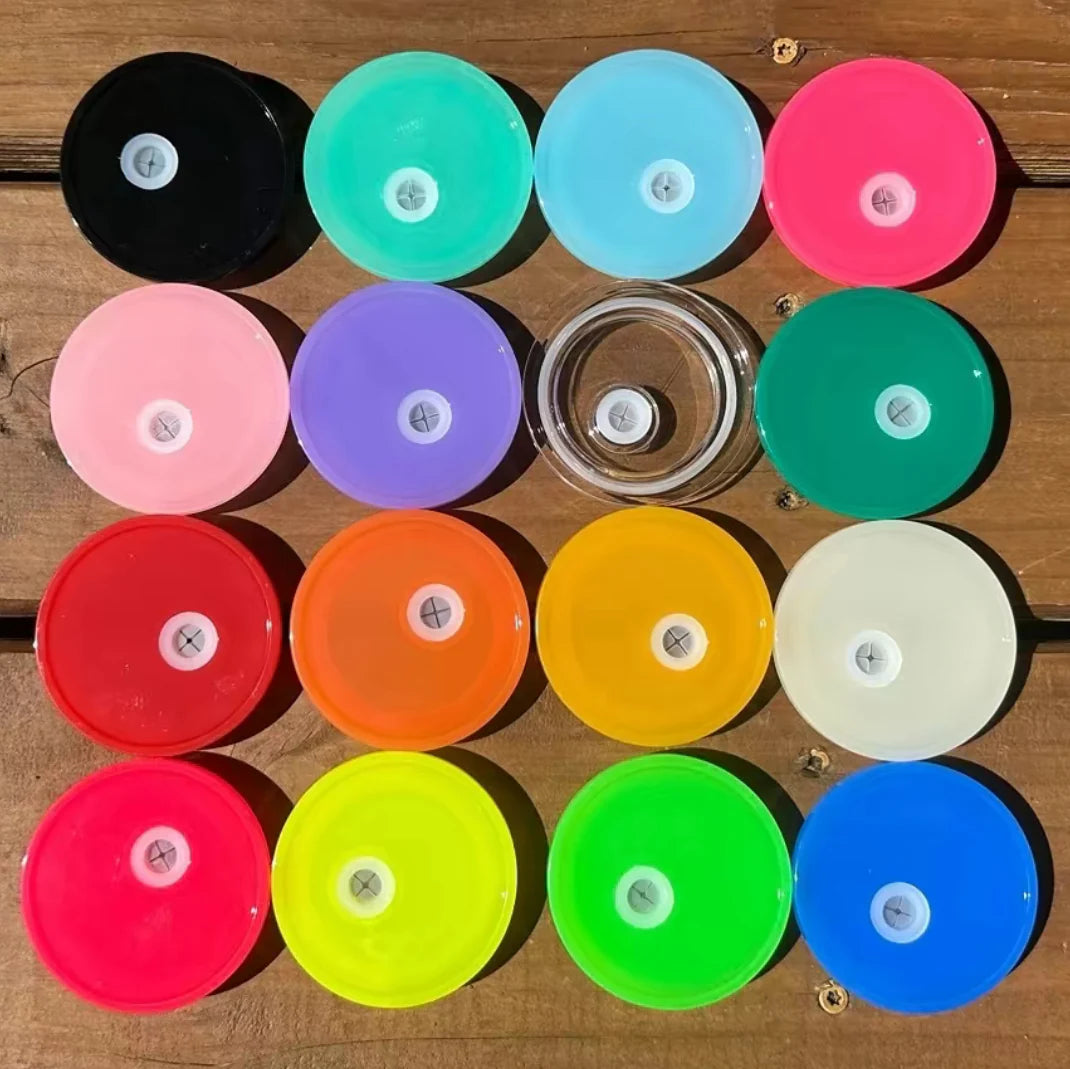 Assorted colorful tumbler lids on a wooden surface