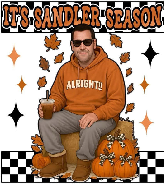 Person wearing an orange hoodie with 'ALRIGHT!' text, holding a drink, surrounded by autumn-themed decorations.