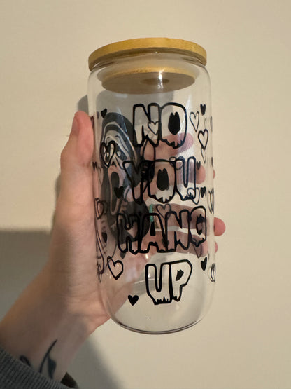 A hand holding a glass cup with no you hang up quote 