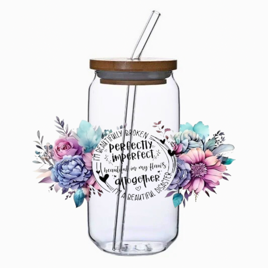 Clear glass tumbler with floral design and text on a white background