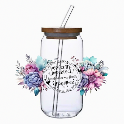 Clear glass tumbler with floral design and text on a white background