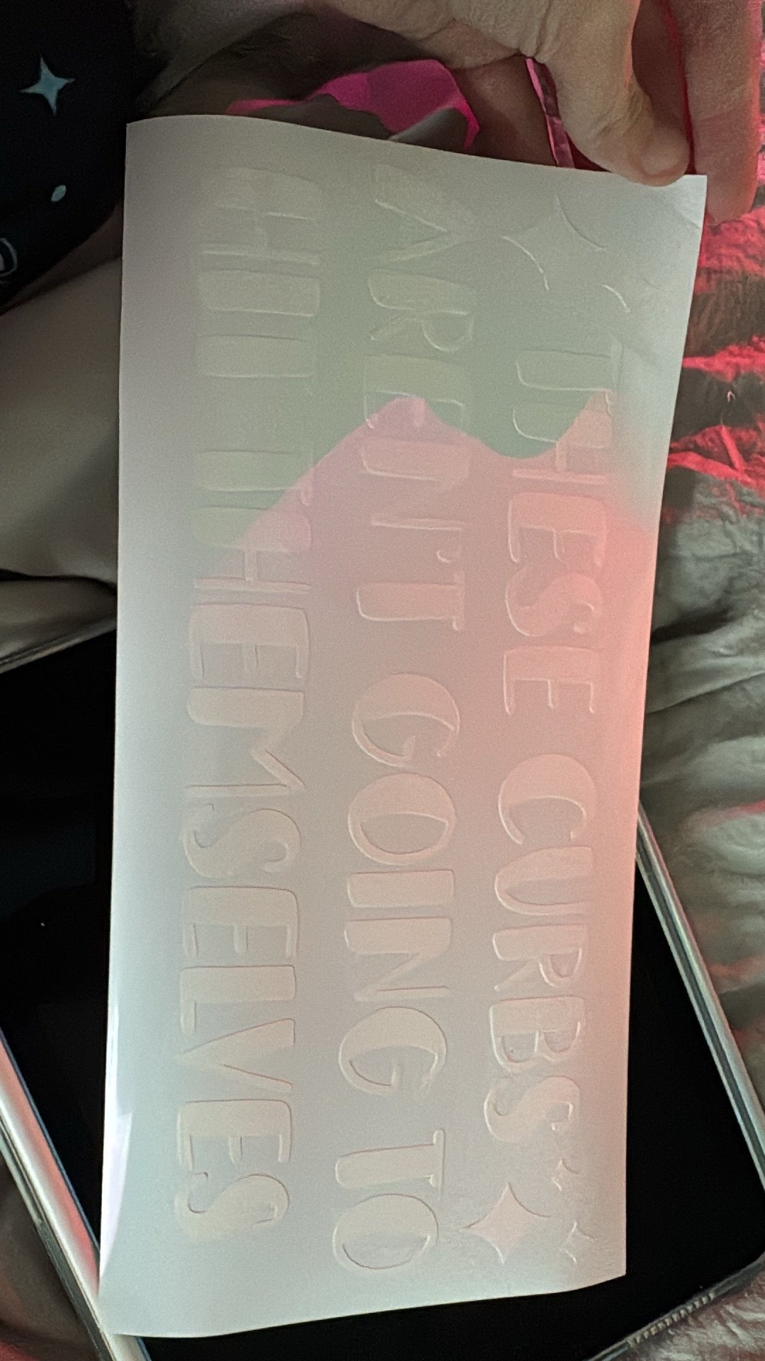 A white custom vinyl decal with text on it, placed on a surface.