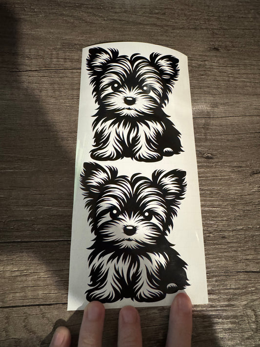 A sheet of vinyl decals featuring two black and white images of puppies.
